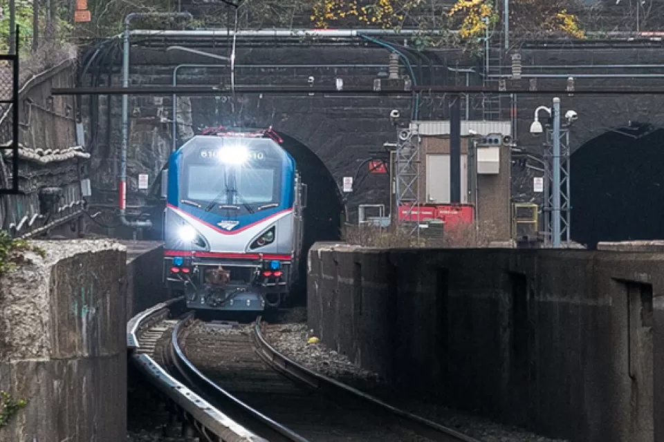 Amtrak train coming out of stone tunnel